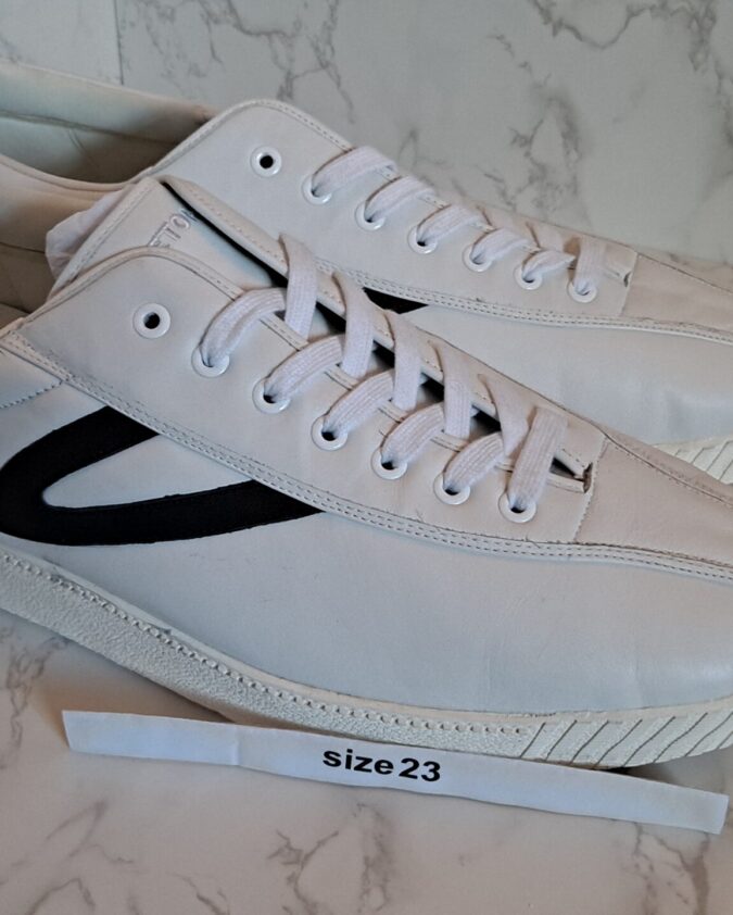 Pair of white sneakers with black stripe